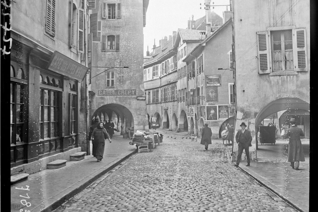 Rue pavée de la Vieille Ville d'Annecy bordée d'arcades, photographiée en 1922