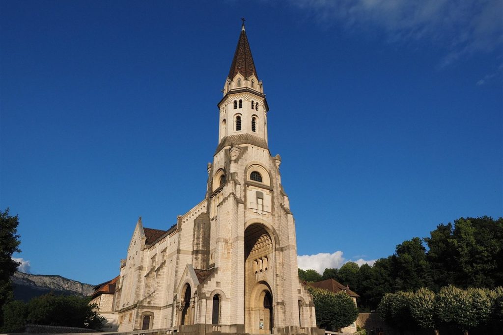 Façade et clocher blanc de la basilique de la Visitation à Annecy sous un ciel bleu