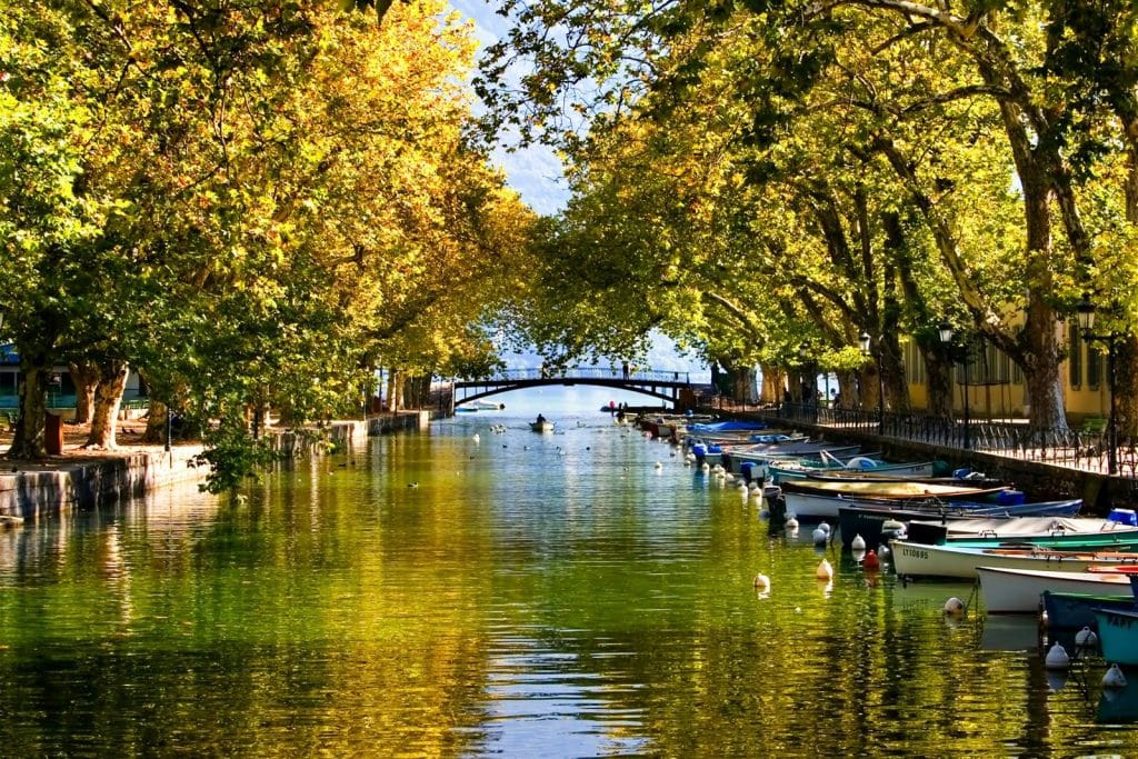 Le canal du Vassé sous les platanes en automne, barques amarrées et Pont des Amours au fond