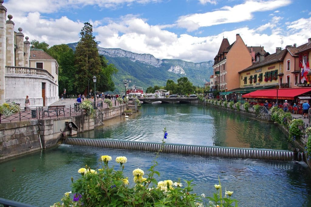 Une vanne barre le Thiou en amont du pont Perrière, avec les quais et les montagnes au fond