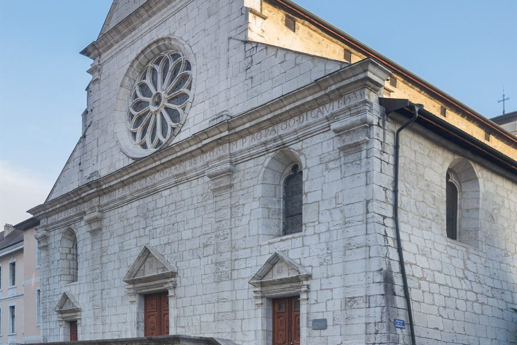 Façade Renaissance de la cathédrale Saint-Pierre d'Annecy avec sa rosace et l'inscription latine datée de 1535