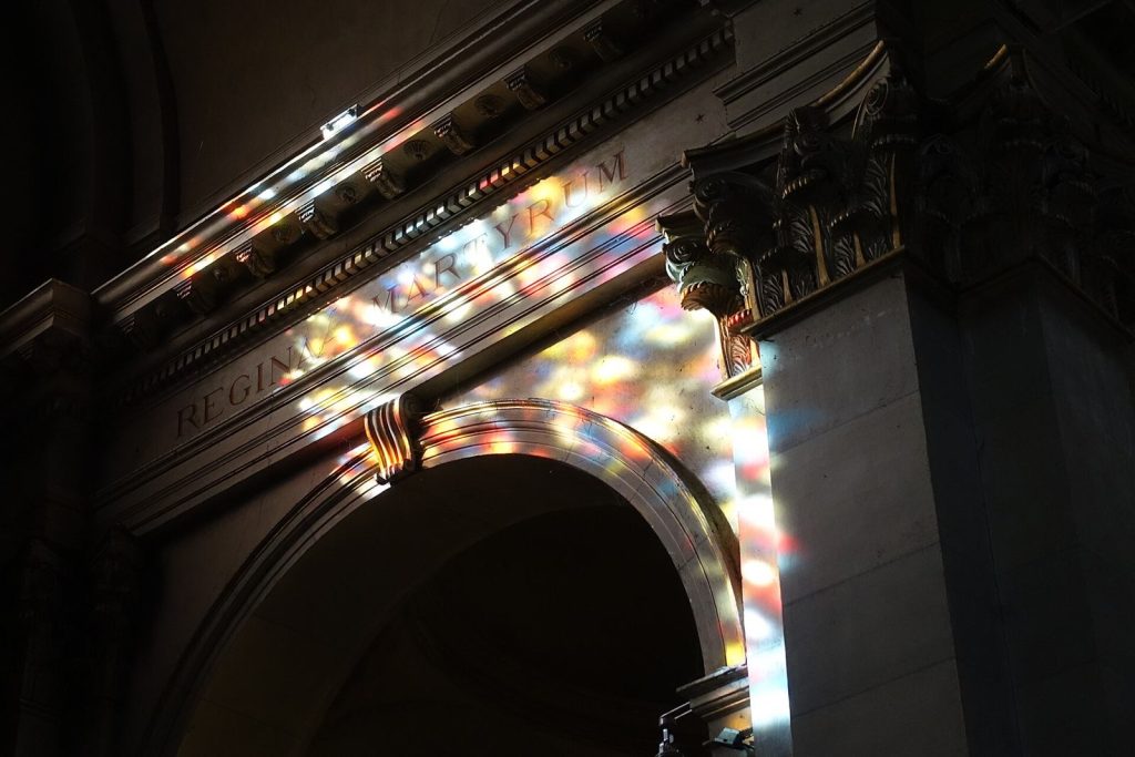 Lumière colorée des vitraux sur un arc de l'église Notre-Dame-de-Liesse d'Annecy