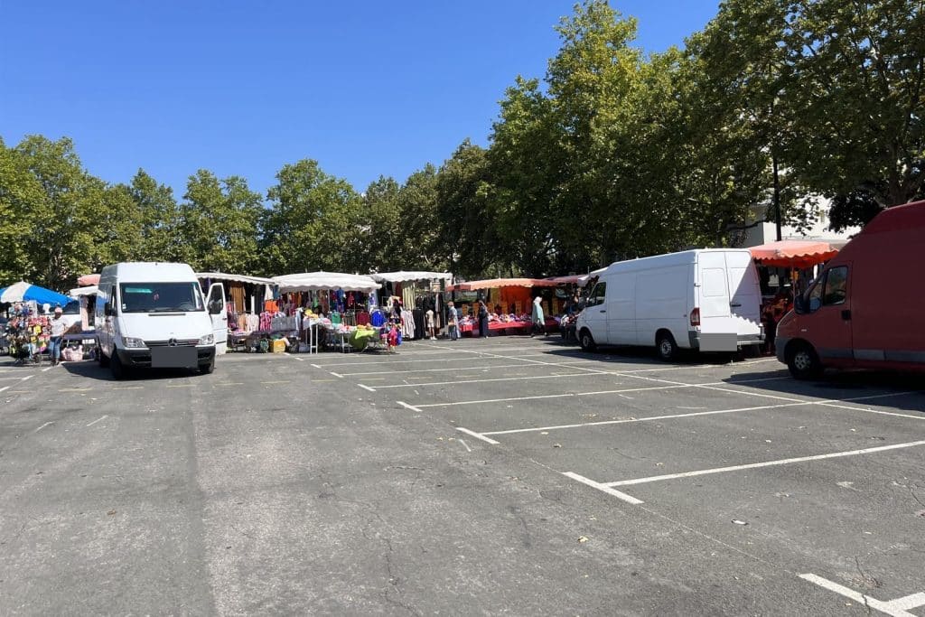 Étals et camionnettes du marché du mardi sur la place des Romains, dans le quartier des Fins à Annecy