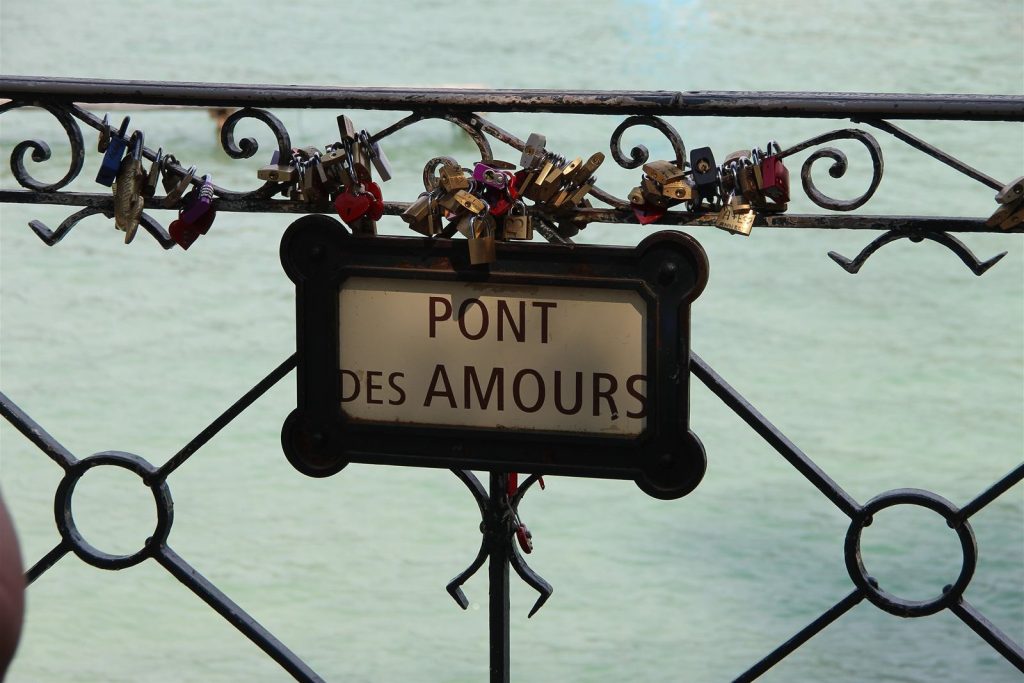 Plaque « Pont des Amours » sur la rambarde, avec des cadenas accrochés