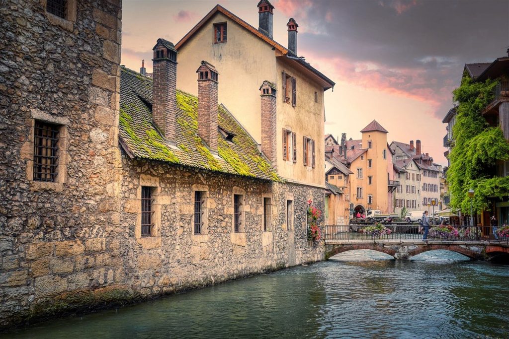 Le Palais de l'Isle à Annecy, ses fenêtres grillagées au-dessus du Thiou, au crépuscule
